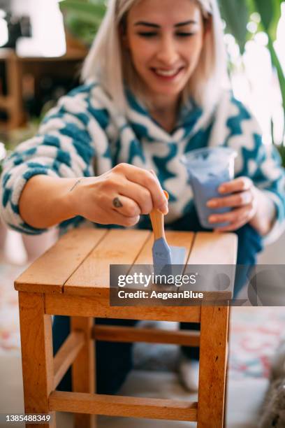 junge frau malt zu hause einen stuhl - holz streichen stock-fotos und bilder