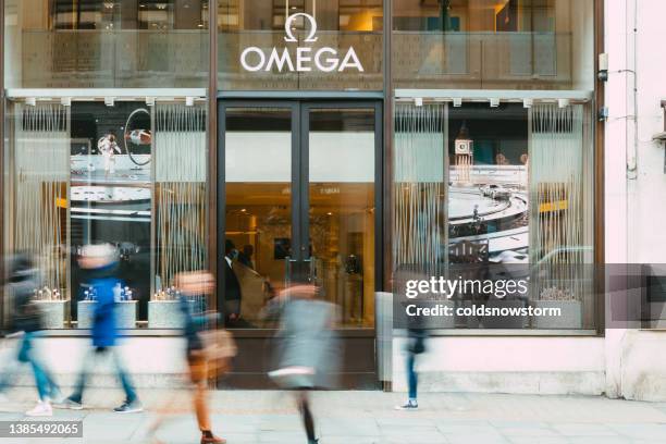 movimiento borroso de las personas que pasan por la tienda de relojes omega en la calle de la ciudad - omega marca de moda fotografías e imágenes de stock