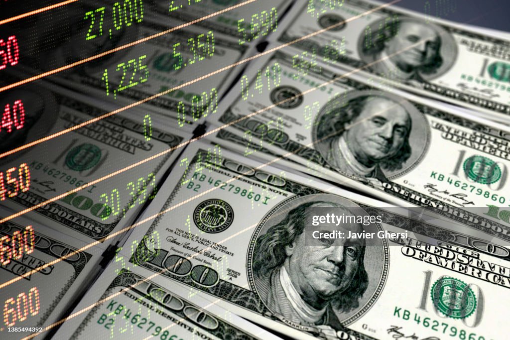 Economy graph: 100 dollar bills and stock market data dashboard