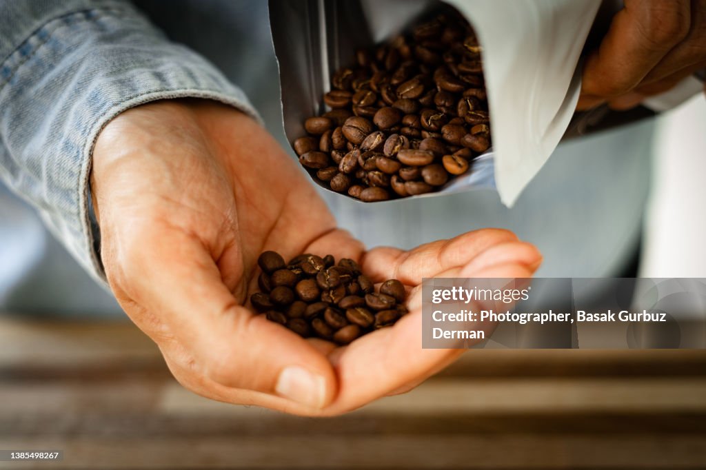 Close up of hand cupping coffee beans