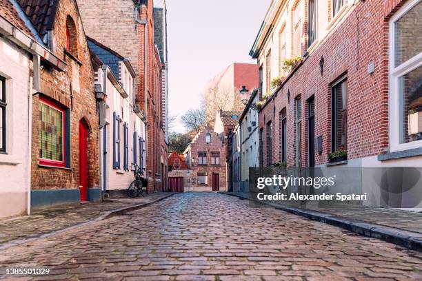 cobbled street in bruges old town, belgium - belgium street stock pictures, royalty-free photos & images