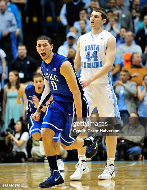 Teammates congratulate of the Duke Blue Devils reacts after his last-second game-winning three point basket over Tyler Zeller of the North Carolina...