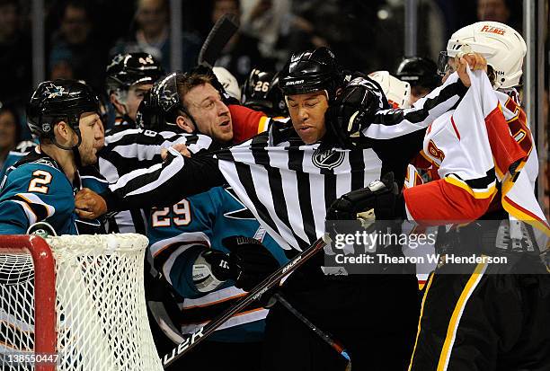 Linesman Jay Sharrers breaks up a fight between Jim Vandermeer, Ryane Clowe of the San Jose Sharks and Krys Kolanos of the Calgary Flames at HP...