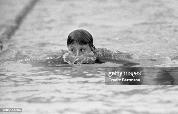 Donna de Verona peeps above the water level to check on her competitors during the 200-meter individual medley at the AAU Women’s Swimming and Diving...