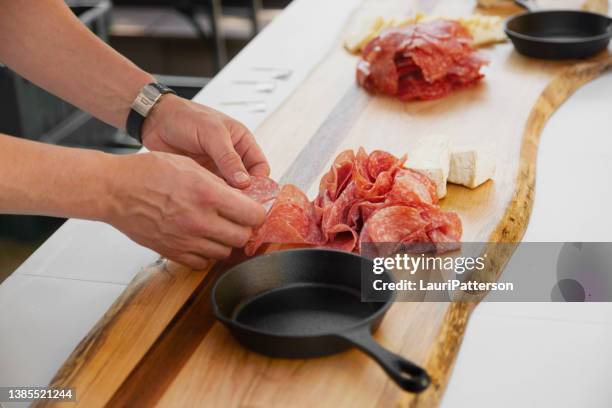 chef preparing a charcuterie board - 意大利辣味腸 個照片及圖片檔