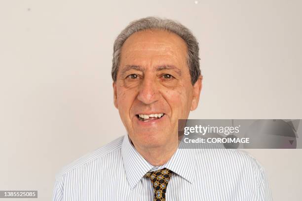 portrait of confident senior man smiling against white background - südeuropa stock-fotos und bilder
