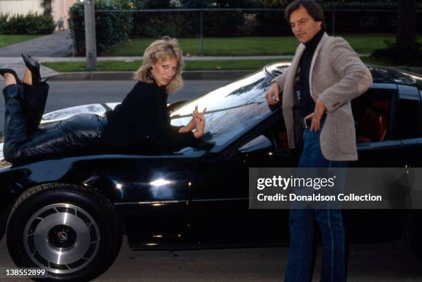 Celebrity couple Josh Taylor and Sandahl Bergman pose for a portrait on their Corvette at their home in circa 1985 in Los Angeles, California.