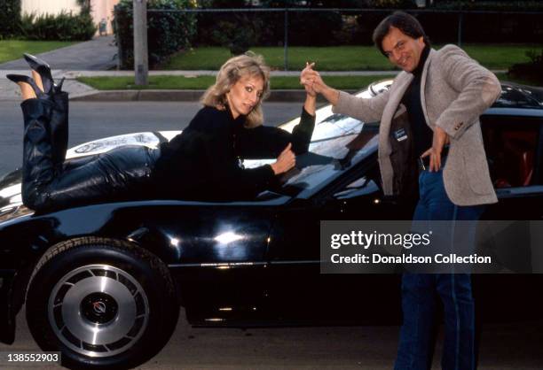 Celebrity couple Josh Taylor and Sandahl Bergman pose for a portrait on their Corvette at their home in circa 1985 in Los Angeles, California.