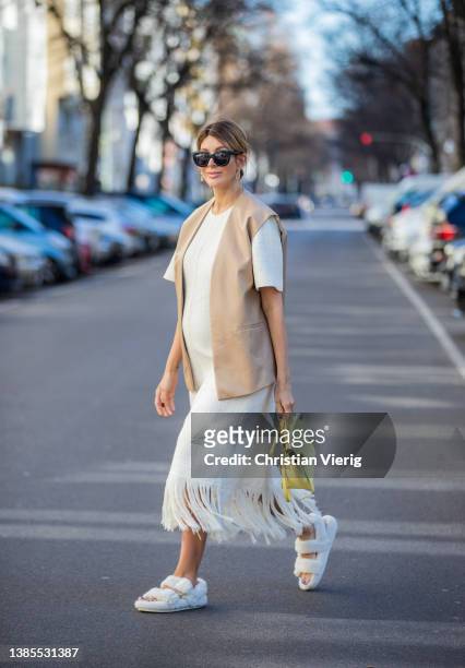 Victoria Scheu is seen wearing white dress with short sleeves & fringes Zara, brown beige faux leather vest Zara, faux fur sandals H&M, yellow bag...