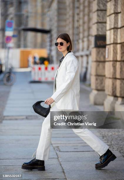 Jacqueline Zelwis seen wearing white Designers’ Remix pants & blazer, Mads Norgaard leather shirt, Dr. Martens Boots, Nunoo bag, Maison Nathalie...