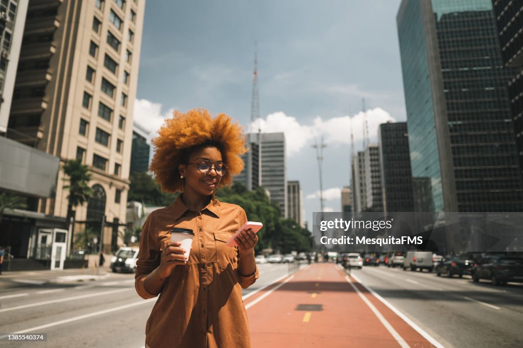 Donna afro che utilizza lo smartphone su Avenida Paulista