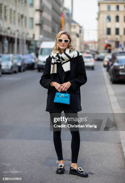 Mandy Bork is seen wearing black leggings pants Zara, Blazer & striped jumper worn over shoulders Other stories, loafers Roger Vivier, blue bag...