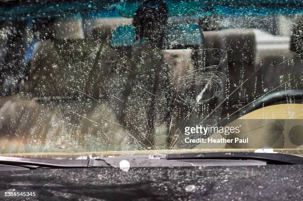 front view of a car windshield shattered and damaged after a hail storm - hail foto e immagini stock