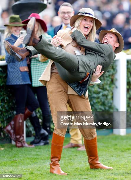 Penny Lancaster lifts jockey Frankie Dettori off the ground as they attend day 1 'Champion Day' of the Cheltenham Festival at Cheltenham Racecourse...