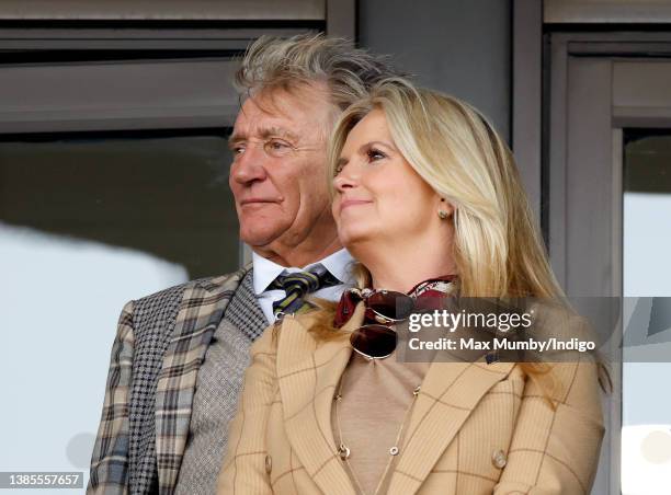 Sir Rod Stewart and Penny Lancaster watch the racing as they attend day 1 'Champion Day' of the Cheltenham Festival at Cheltenham Racecourse on March...