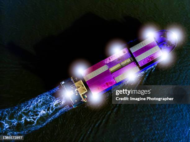 aerial top view, a small container ship sailing in the sea at night in the light of the moon.  about the business of transportation, import and export by container ship. - night delivery stock pictures, royalty-free photos & images