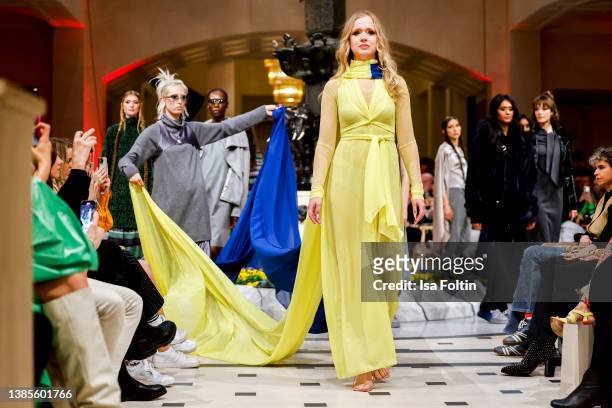 Ukrainian dancer Nataliia Ovcharova, wearing a dress in the national colours of Ukraine yellow and blue, and models walk the runway at the Anja...