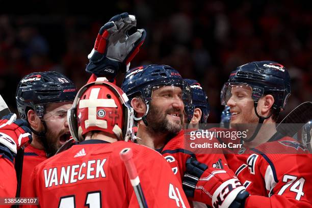 Alex Ovechkin of the Washington Capitals and members of the team celebrate their 4-3 shootout win against the New York Islanders at Capital One Arena...