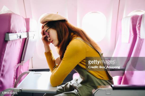 portrait of asian passenger feeling tired from traveling on long flight. - pressure airplane stock pictures, royalty-free photos & images