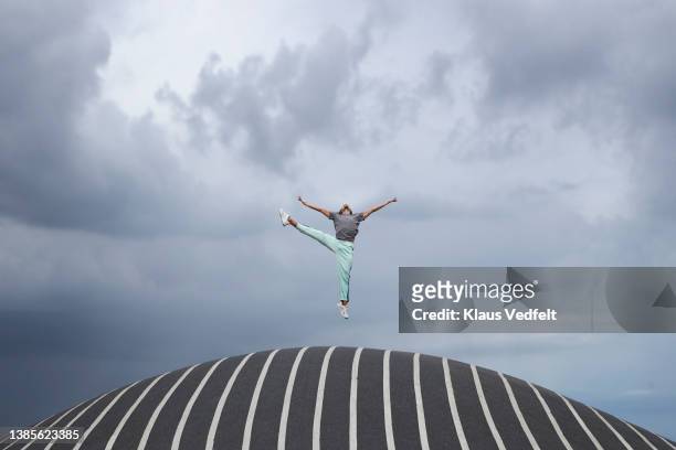 male ballet dancer jumping on road - freedom fotografías e imágenes de stock