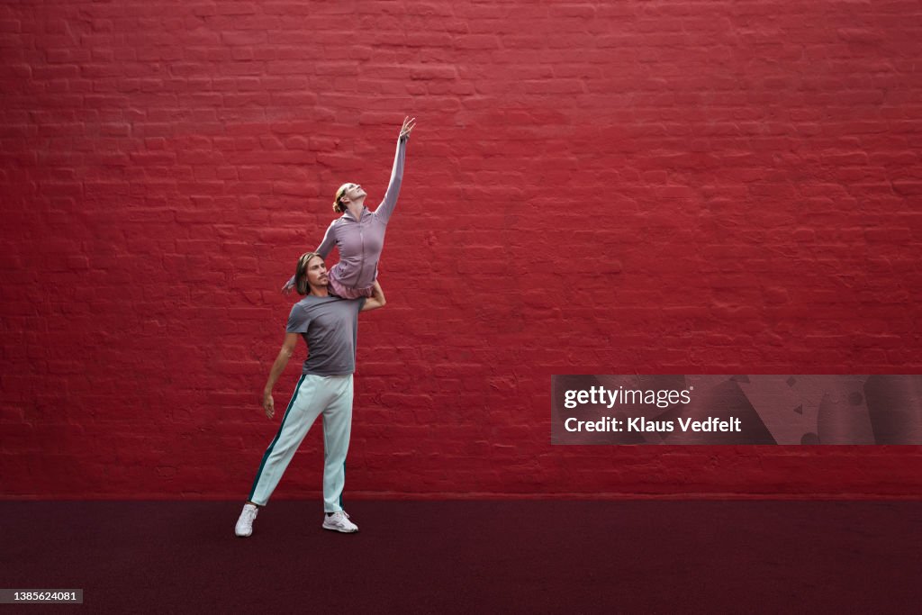 Dancers practicing ballet against wall