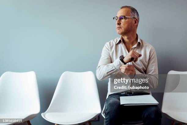 worried man waiting in waiting room. - man waiting stock pictures, royalty-free photos & images