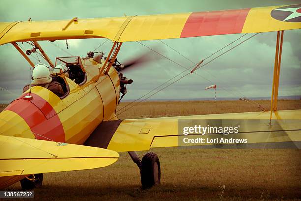 yellow bi plane takes off - biplane stock pictures, royalty-free photos & images