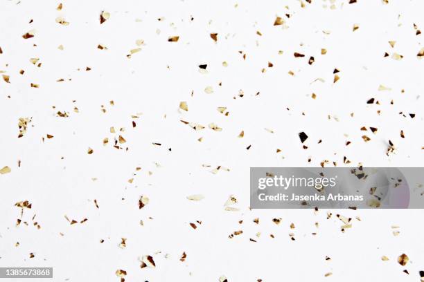 golden confetti on the white background - konfettiregen stock-fotos und bilder