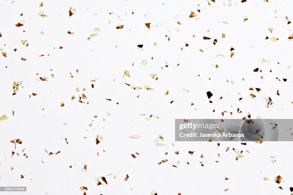 Golden confetti on the white background