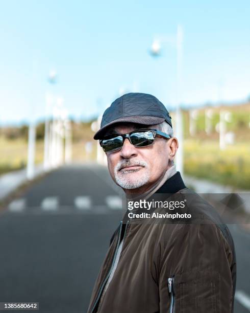 portrait of stylish elderly man on a sunny day - getönte sonnenbrille stock-fotos und bilder