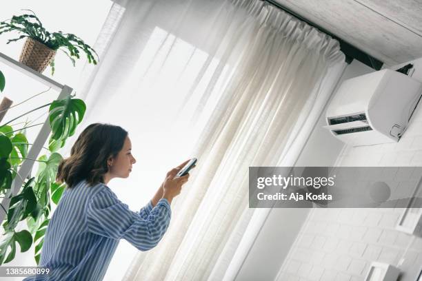 turning on the air conditioner. - air conditioner interior wall stock pictures, royalty-free photos & images