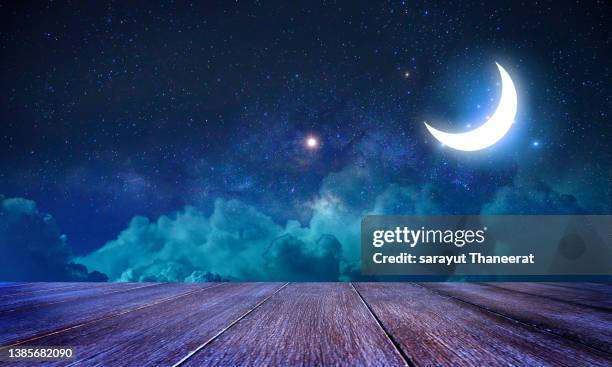 ramadan kareem moon on table with abstract defocused lights - ramadan moon stockfoto's en -beelden