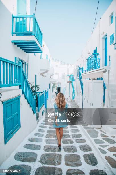 young tourist woman walks through the streets of mykonos island, cyclades, greece - grekiska övärlden bildbanksfoton och bilder