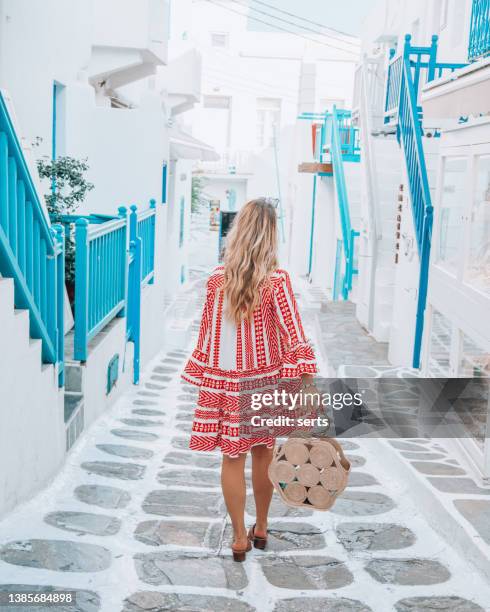 young tourist woman walks through the streets of mykonos island, cyclades, greece - cyclades islands stock pictures, royalty-free photos & images
