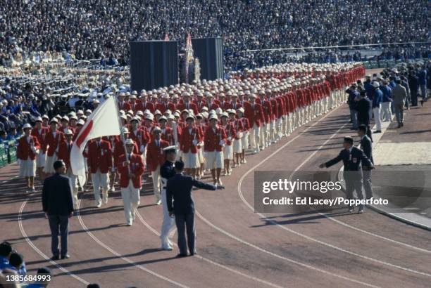 Japanese swimmer Makoto Fukui holds the national flag as he leads the Japan Olympic team on the track during the Parade of Nations section of the...