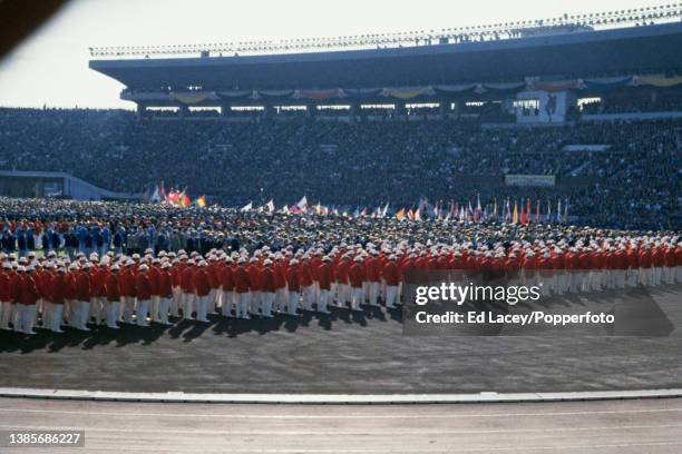 With members of the Japanese Olympic team in the foreground, athletes from different nations take part in the opening ceremony for the 1964 Summer...