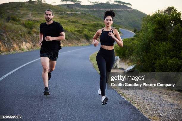 casal jovem em forma correndo juntos ao longo de uma trilha cênica - corrida fora de pista - fotografias e filmes do acervo