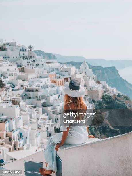 young woman enjoys travelling and looking at view in santorini, greece - luxury cruise ship stock pictures, royalty-free photos & images