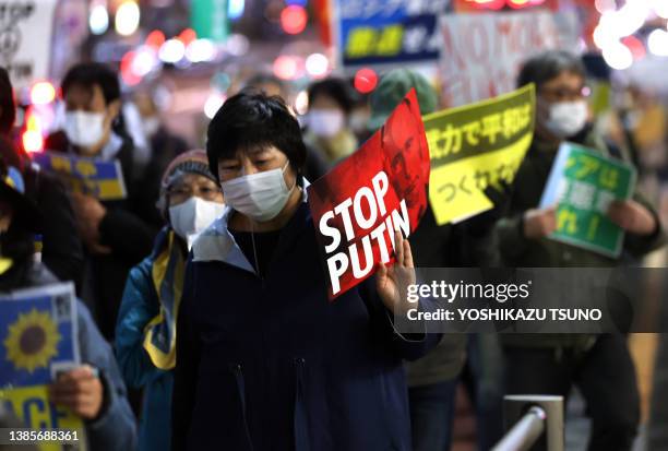 Des manifestants brandissent des pancartes contre l'invasion militaire de la Russie en Ukraine lors d'une marche à Tokyo le 11 mars 2022.