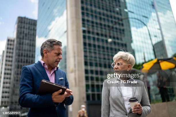 coworkers talking and walking in the street - chief financial officers stock pictures, royalty-free photos & images