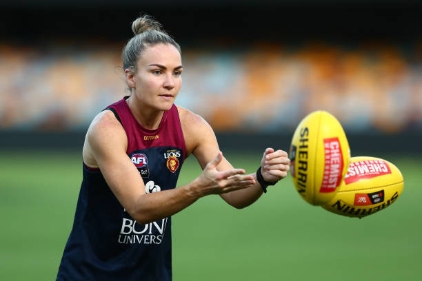 Emily Bates handballs during a Brisbane Lions AFLW training session at The Gabba on March 16, 2022 in Brisbane, Australia.