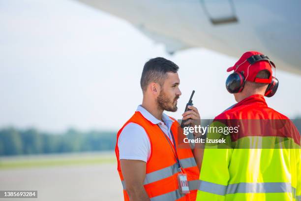 airport bodenservice-männer bei der arbeit - airport ground crew uniform stock-fotos und bilder