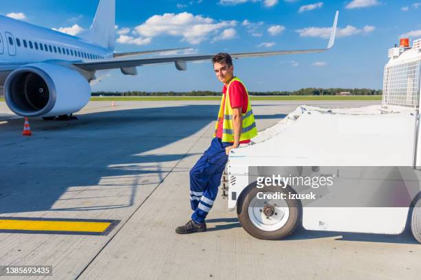 flughafen bodenservice junger mann steht auf der landebahn - airport ground crew uniform stock-fotos und bilder