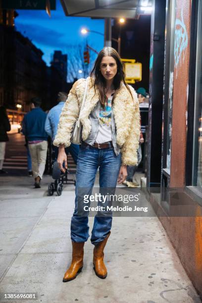 German model Rachel Marx wears a cropped vintage fur tan jacket, graphic white t-shirt, blue jeans tucked into brown cowboy boots after the Proenza...