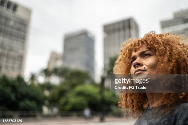 contemplative mid adult woman in the city - female body piercing stock pictures, royalty-free photos & images