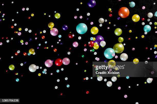 clorful sugar ball flying in mid air in black background - bouncing stockfoto's en -beelden