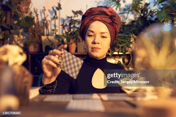 female enchantress spreading tarot cards at table - fortune teller - fotografias e filmes do acervo