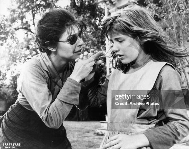 Anne Bancroft holding Patty Duke's hand to teach her a new word in a scene from the film 'The Miracle Worker', 1962.