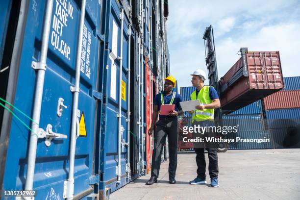 multi-ethnic men working at shipping port - construction crane asia stockfoto's en -beelden