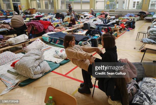 Sisters Sophia and Anna Utikalko, who together with their mother and other family members fled war-torn Ukraine, pass the time in a shelter set up...